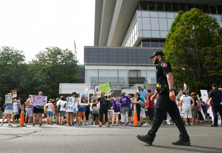 Family and friends who have lost loved ones to OxyContin and opioid overdoses protest outside Purdue Pharma headquarters in Stamford, Conn. on Aug. 17, 2018. 