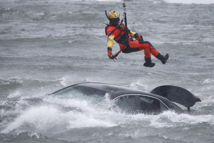 A U.S. Coast Guard diver is lowered from a hovering helicopter to pull a body from a submerged vehicle stuck in rushing rapids just yards from the brink of Niagara Falls on Wednesday in Niagara Falls, N.Y. 