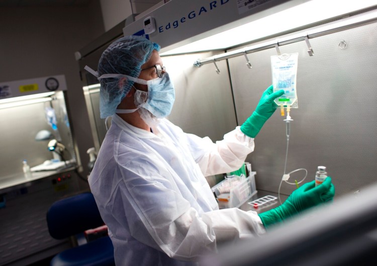 Dan Pelletier, a pharmacy technician specialist at Maine Medical Center, demonstrates the process of preparing anitibodies used to treat COVID19 patients. 