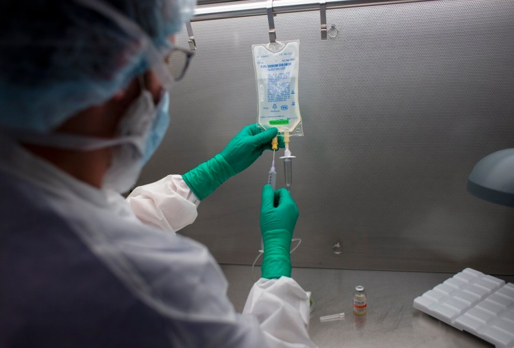 Dan Pelletier, a pharmacy technician specialist at Maine Medical Center, demonstrates the process of preparing antibodies used to treat COVID19 patients in September. 