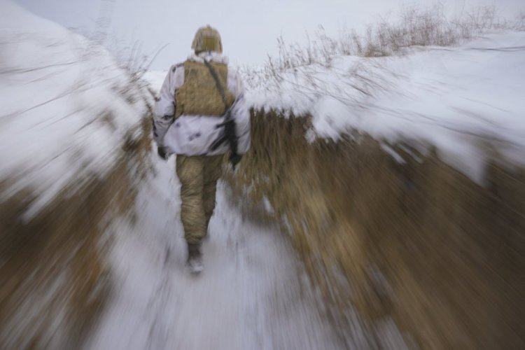 A Ukrainian serviceman walks through a trench Thursday on the front line in the Luhansk area, eastern Ukraine.