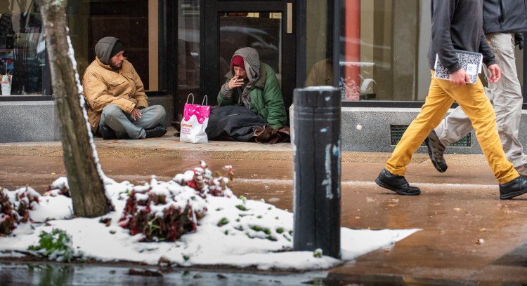 Arthur Murray, left, and Christopher Larochelle find shelter from the rain and snow in November in the foyer of a business on Lisbon Street in Lewiston. Murray "couch surfs" with friends most nights while Larochelle moves from town to town. "I have a place I built in Poland, but there are people squatting there that are worse off than me so I'm just working wherever I can and doing what I can to get by" he said with a smile.