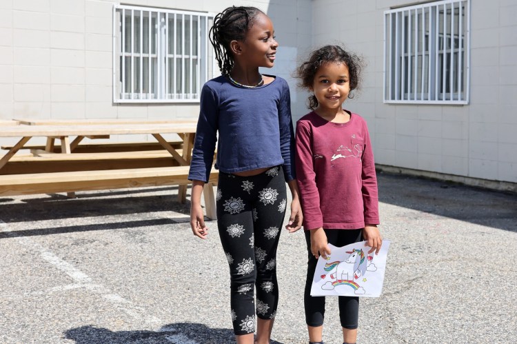 PORTLAND, ME - MAY 8: Sisters Emilia, 6, left, and Fatima Toubaji, 5, who are recent arrivals from Angola, stand outside Portland Public Schools district office in Portland on Monday after Emilia enrolled in kindergarten. Enrollment is at capacity for pre-kindergarten, so Fatima will have to wait until next school year to attend kindergarten. (Staff photo by Ben McCanna/Staff Photographer)